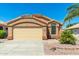 Exterior view of a tan house with a double-car garage and desert landscaping at 18112 W Spencer Dr, Surprise, AZ 85374