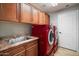 Laundry room with red appliances and wood cabinets at 21320 N 56Th St # 2145, Phoenix, AZ 85054