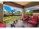 Relaxing patio with red chairs and a view of the lush green landscape at 21320 N 56Th St # 2145, Phoenix, AZ 85054