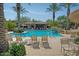 Community pool with lounge chairs and palm trees at 21320 N 56Th St # 2145, Phoenix, AZ 85054