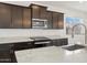 Modern kitchen with dark cabinetry, granite countertops, and stainless steel appliances at 3530 E Alexander Dr, San Tan Valley, AZ 85143