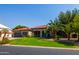 Single-story home with a lush lawn and mature palm trees at 14147 W Greentree S Dr, Litchfield Park, AZ 85340