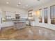 Bright kitchen featuring white cabinets, granite island, and tile flooring at 41253 N Whistling Strait Ct, Anthem, AZ 85086
