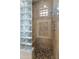 Shower stall with glass block wall, pebble floor, and tiled walls at 41253 N Whistling Strait Ct, Anthem, AZ 85086
