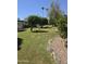 Landscaped backyard with mature trees and a grassy area at 10617 W Deanne Dr, Sun City, AZ 85351