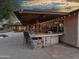 Outdoor kitchen with bar seating, grill, and string lights at 6614 W Sweetwater Ave, Glendale, AZ 85304