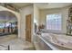 Relax in this luxurious bathroom featuring a large tub and glass block window at 6614 W Sweetwater Ave, Glendale, AZ 85304