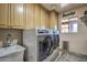 Laundry room with washer, dryer, cabinets, and utility sink at 6614 W Sweetwater Ave, Glendale, AZ 85304