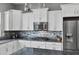 Modern kitchen featuring white cabinetry, granite counters, and a gas cooktop at 41758 W Cribbage Rd, Maricopa, AZ 85138