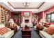 Inviting library with comfortable seating, a fireplace, and extensive bookshelves at 41758 W Cribbage Rd, Maricopa, AZ 85138