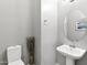 Small half bathroom with pedestal sink and toilet at 41758 W Cribbage Rd, Maricopa, AZ 85138