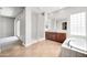 Elegant bathroom with double sinks, large soaking tub, and glass block shower at 26886 N 90Th Ave, Peoria, AZ 85383