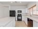 Updated kitchen with white cabinets, black appliances and tile floor at 29759 N Desert Angel Dr, San Tan Valley, AZ 85143
