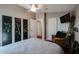 Bedroom featuring a queen bed, ceiling fan, and wicker chair at 41301 W Sussex Dr, Maricopa, AZ 85138