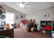 Bright bedroom with a double bed, built-in shelving, and a ceiling fan at 41301 W Sussex Dr, Maricopa, AZ 85138