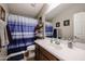 Clean bathroom with a tub shower combo, vanity, and linen storage at 41301 W Sussex Dr, Maricopa, AZ 85138