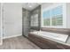 Bathroom with soaking tub and glass-enclosed shower at 28001 N 92Nd Ave, Peoria, AZ 85383