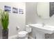 Clean and modern bathroom with pedestal sink and round mirror at 28001 N 92Nd Ave, Peoria, AZ 85383