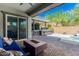 Covered patio with fire pit, outdoor kitchen, and pool access at 28001 N 92Nd Ave, Peoria, AZ 85383