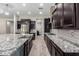Modern kitchen with dark cabinetry, granite countertops, and stainless steel appliances at 28001 N 92Nd Ave, Peoria, AZ 85383