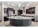 Large kitchen island with granite countertop and dark lower cabinets at 28001 N 92Nd Ave, Peoria, AZ 85383