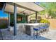 Modern outdoor kitchen with grill, bar seating, and TV at 28001 N 92Nd Ave, Peoria, AZ 85383