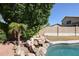 Relaxing backyard oasis with a sparkling pool, waterfall feature, and lush landscaping at 26028 N 66Th Dr, Phoenix, AZ 85083