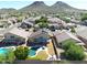 Aerial view of house with pool and solar panels, nestled in a neighborhood with mountain backdrop at 26028 N 66Th Dr, Phoenix, AZ 85083