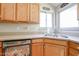 Bright kitchen featuring double sink, wood cabinets, and corner window at 26028 N 66Th Dr, Phoenix, AZ 85083
