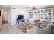 Bright living room features a cozy sectional sofa, built-in shelving, and tile flooring at 26028 N 66Th Dr, Phoenix, AZ 85083