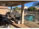 Covered patio with pool views, seating, and a grill at 18527 W Caribbean Ln, Surprise, AZ 85388
