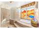 Bathroom with walk-in shower, soaking tub, stained glass window, and glass block window at 34617 N Desert Ridge Dr, Scottsdale, AZ 85262