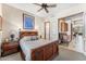 Bedroom with wooden furniture, ceiling fan, and access to an attached office or den at 34617 N Desert Ridge Dr, Scottsdale, AZ 85262