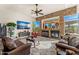 Living room with stone fireplace, large windows, and view of the backyard at 34617 N Desert Ridge Dr, Scottsdale, AZ 85262