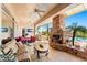 Covered patio with fireplace, outdoor kitchen, and seating area by the pool at 34617 N Desert Ridge Dr, Scottsdale, AZ 85262