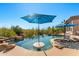 Close-up of negative edge pool with swim-up table and umbrella at 34617 N Desert Ridge Dr, Scottsdale, AZ 85262