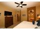 Spacious Primary bedroom with a large TV and ensuite bathroom at 15103 W Sentinel Dr, Sun City West, AZ 85375