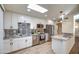 Remodeled kitchen with granite countertops, white cabinets, and tile backsplash at 19202 N Signal Butte Cir, Sun City, AZ 85373
