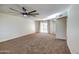 Spacious living room featuring a ceiling fan and access to a patio at 19202 N Signal Butte Cir, Sun City, AZ 85373