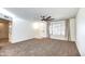 Bright and airy living room with neutral carpet and ceiling fan at 19202 N Signal Butte Cir, Sun City, AZ 85373