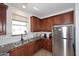 Corner view of kitchen with granite countertops, stainless steel appliances, and wooden cabinetry at 4306 E Tyson St, Gilbert, AZ 85295