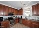 Modern kitchen with granite countertops, stainless steel appliances, and wooden cabinetry at 4306 E Tyson St, Gilbert, AZ 85295