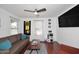 Cozy living room featuring hardwood floors, a brown sofa, and a large TV at 4306 E Tyson St, Gilbert, AZ 85295