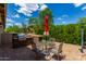 Outdoor patio dining area with built-in grill at 37143 N Greythorn Cir, Carefree, AZ 85377