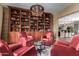 Cozy library with built-in bookshelves, comfortable seating, and a unique chandelier at 37143 N Greythorn Cir, Carefree, AZ 85377