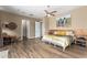 Spacious bedroom with wood-look floors, a large bed, and a wooden headboard at 37143 N Greythorn Cir, Carefree, AZ 85377