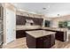 Open kitchen with large island, stainless steel appliances, and dark wood cabinets at 37143 N Greythorn Cir, Carefree, AZ 85377