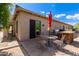 Outdoor patio with a dining table, built-in grill, and red umbrella at 37143 N Greythorn Cir, Carefree, AZ 85377