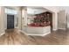Bright entryway with wood-look tile flooring, a view of a library, and a dark-stained wooden door at 37143 N Greythorn Cir, Carefree, AZ 85377