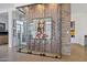 Glass-enclosed wine cellar with a modern metal rack and artwork at 2017 N 1St Ave, Phoenix, AZ 85003